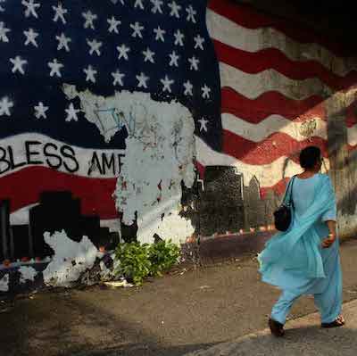 person in Queens in front of flag