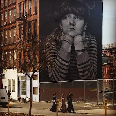 Familia de judios ortodoos con arte callejera en un tour de contrastes a pie en Brooklyn