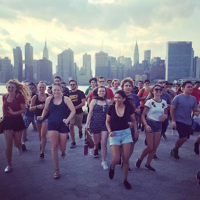 Grupo universitario en Gantry State Park con vistas de skyline de Manhattan 